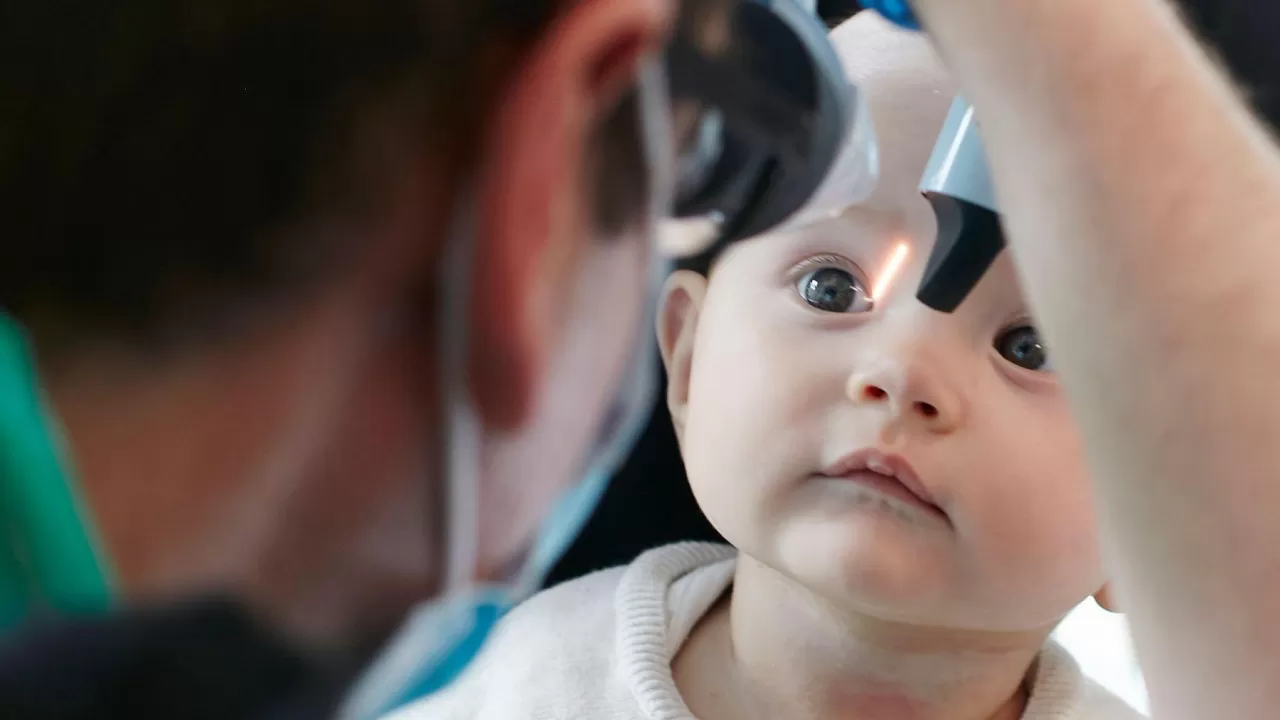 Photo of an infant having their eyes examined
