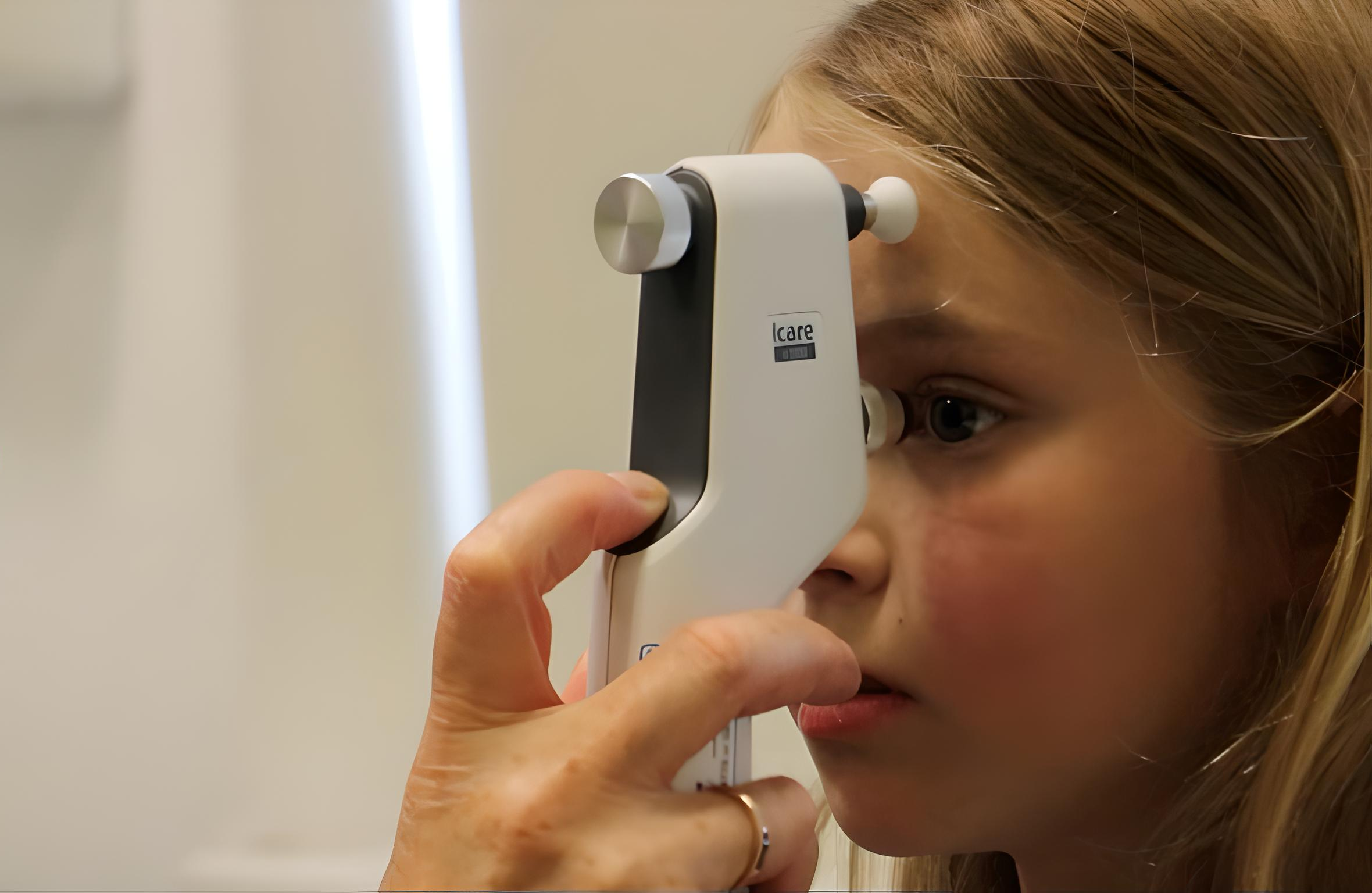 Consultant conducting an eye test on a young person in a hospital consultation room
