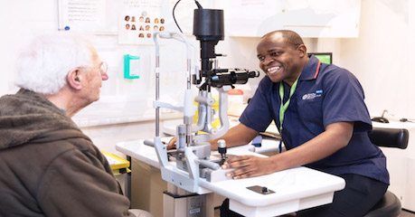 Photo of patient chatting with a smiling member of Moorfields staff in a consultation room