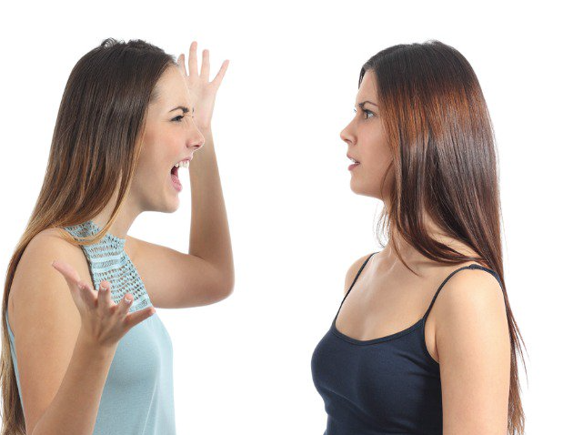 Two people facing each other, one with their hands up and shouting and the other looking confused