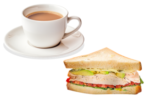 Tea in a cup and saucer next to a sandwich on a white background