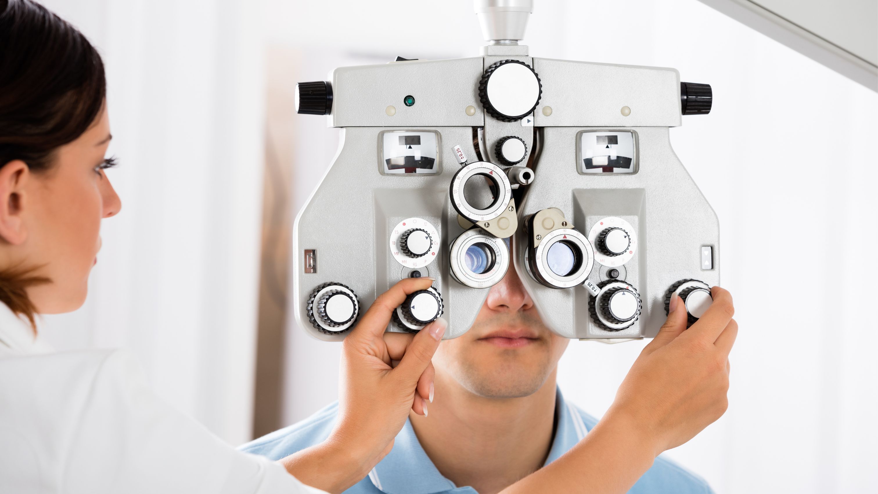 Person adjusting ophthalmological equipment for a patient 