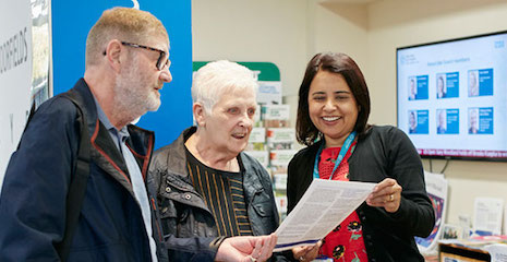 Photo of staff interacting with two patients outside the Health Hub