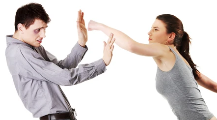 One person leaning over and punching someone with a black eye and hands up, trying to defend themselves