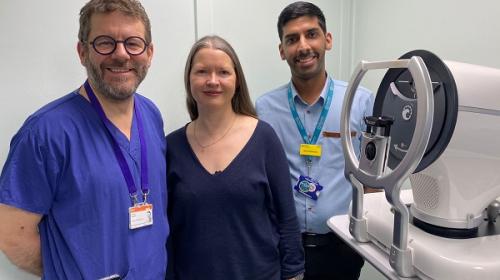 Patient and clinical staff standing next to a glaucoma testing machine