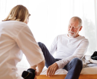 Person helping someone put their socks on